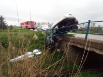 Obrazem: Zábradlí zachránilo auto před pádem z můstku do Koudelovského potoka. Řidič utrpěl zranění